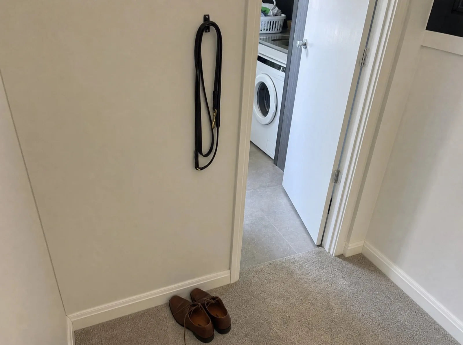 The intact white door frame in the new rental, with shoes untouched beside it